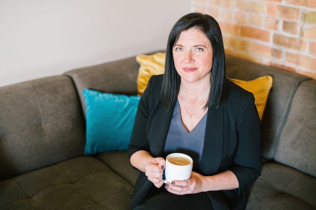 A business owner sitting on a couch enjoying a cup of coffee while reviewing here options for compensation.