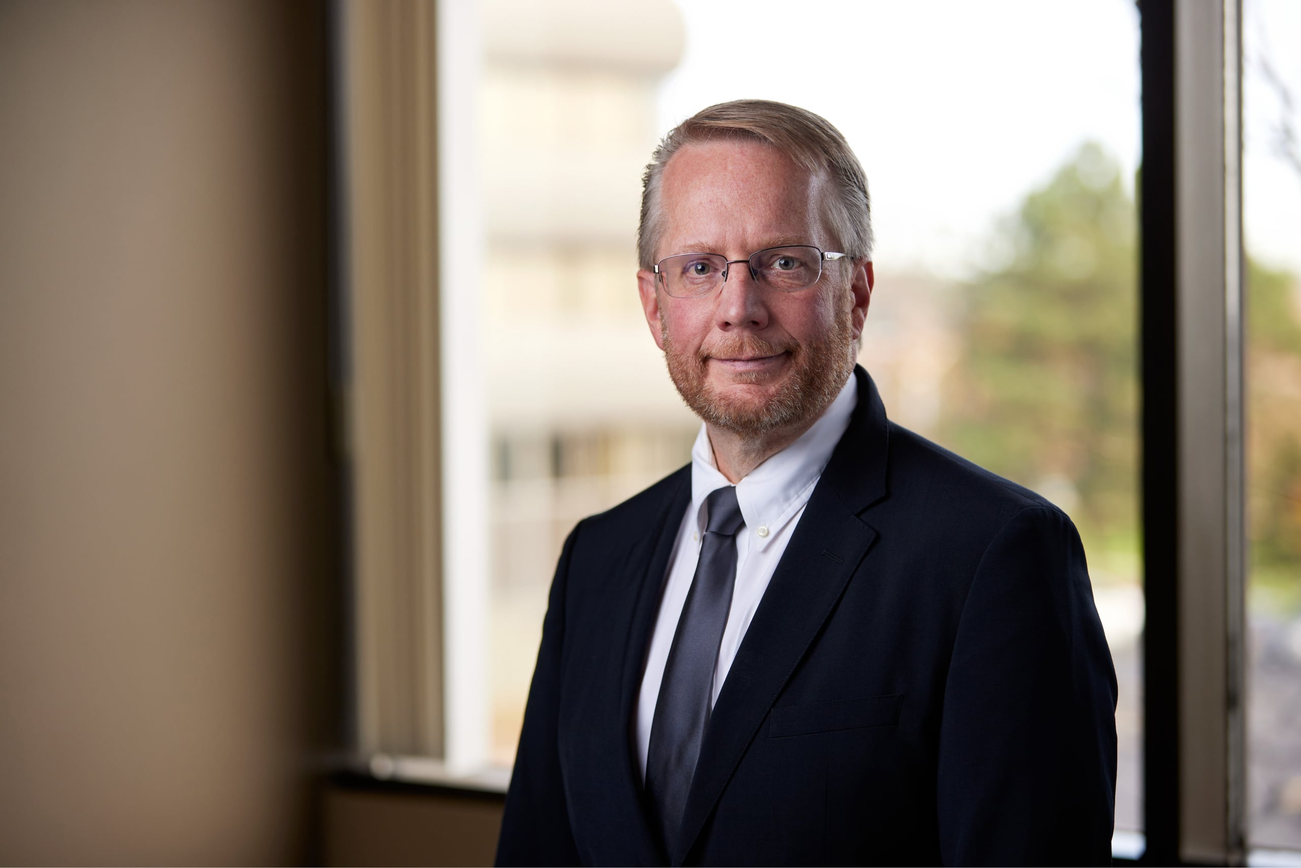 An image of John R. Nunnikhoven CPA in front of a window in Oakville