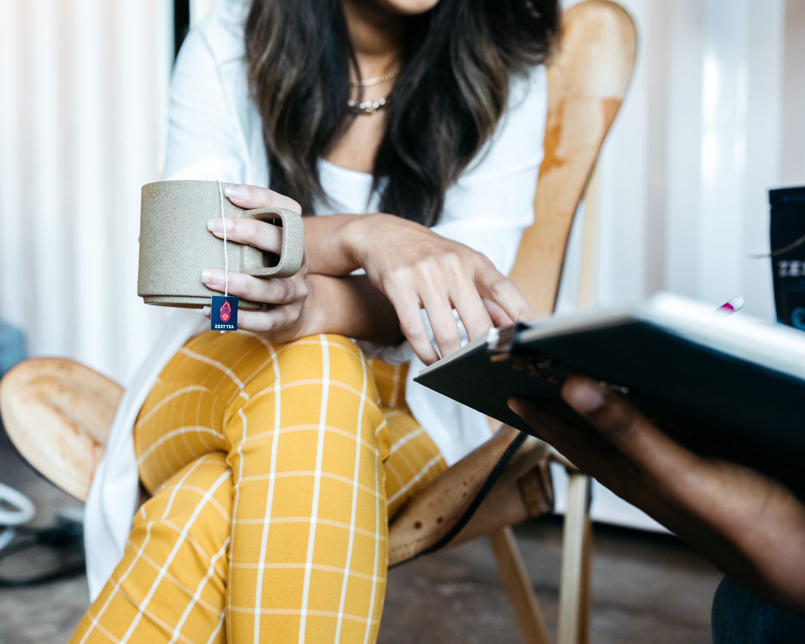 Picture of a team member collaborating with another team member while drinking tea.